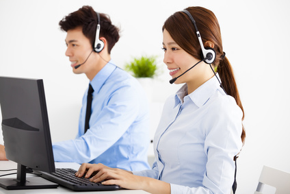 smiling business man and woman with headset working in office